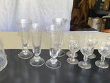 de nombreux verres à vin et une carafe posés sur une table