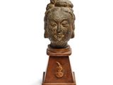 une image représentant la tête d'une femme sculptée sur un socle en bois