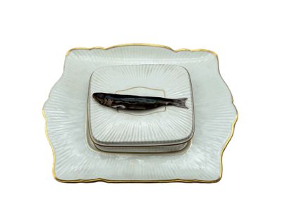 une image représentant un poisson dans une assiette, sur fond blanc