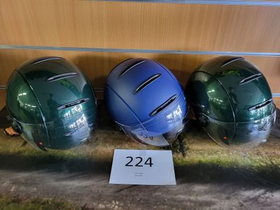 three helmets are lined up on a shelf next to a sign