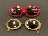 two pairs of red and gold sunglasses sitting on top of a table