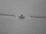 a close up of a white plate with a crown on it