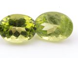 a pair of two oval green peridotites on a white surface