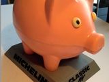 une tirelire orange posée sur un socle noir