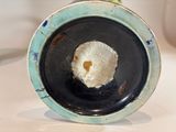 a black and blue plate with a white flower in it