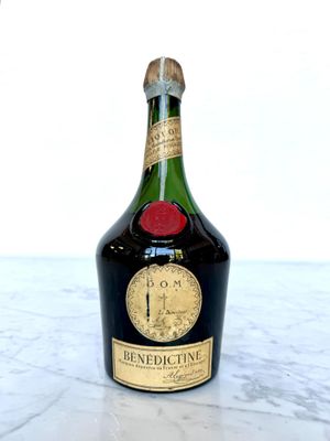 bottle of wine sitting on a marble counter top with a white background