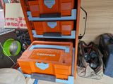 an orange and blue tool box sitting on top of a wooden table