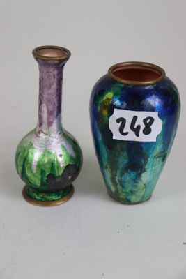 two vases sitting next to each other on a white surface
