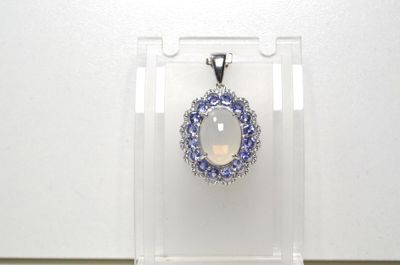 un pendentif en oplite et diamant exposé dans une vitrine transparente