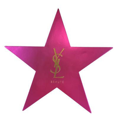 a pink star shaped ornament with the ysl logo on it