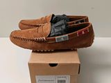 des chaussures de conduite pour homme, de couleur beige, posées sur une boîte en carton