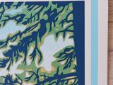 a close up of a blue and green print on a wooden surface
