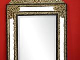 un miroir posé par terre, avec un mur rouge en arrière-plan