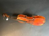 an old violin sitting on top of a table next to a black wall