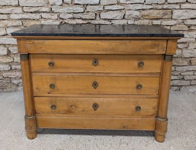 an old wooden chest of drawers with a black marble top