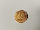 a close up of a gold coin on a white surface