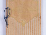 an old book with a blue string tied to it on a white surface