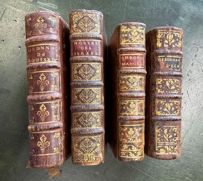 trois vieux livres sont empilés sur une table