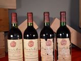 three bottles of red wine are lined up on a table