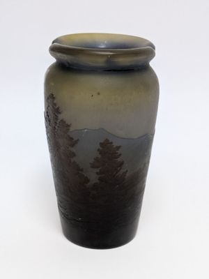a brown vase with trees on it on a white surface