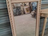 a mirror that is sitting on the floor next to a table