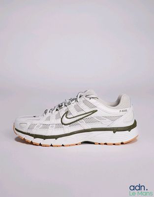 La chaussure de course Nike Air Zoom est blanche et verte.