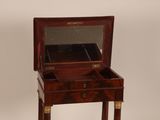 a small wooden table with a mirror on top of it