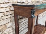 an image of a wooden table against a brick wall