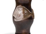 a brown vase with a face on it on a white background