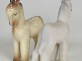two figurines of animals that are standing next to each other