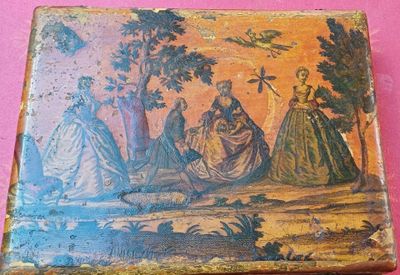 une petite boîte ornée d'une peinture sur un fond rose
