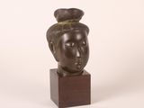 sculpture d'une tête de femme sur une base en bois