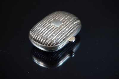 une bague en argent posée sur une surface noire