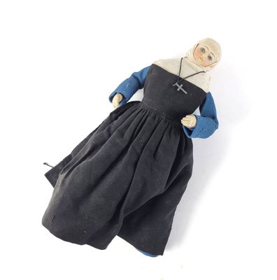 an image of a doll of a nun in a black dress