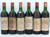 six bottles of wine are lined up in a row on a white surface
