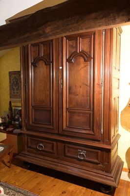 une grande armoire en bois dans le coin d'une pièce