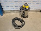 a vacuum and a hose on the floor in front of a wall