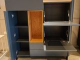 a cabinet with a shelf and a chair in the room