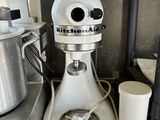 a kitchen aid mixer sitting on a shelf in a kitchen