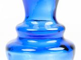 a blue glass vase that is sitting on a table