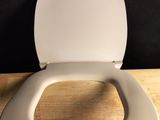 a white toilet with a wooden seat on a wooden floor