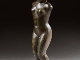 une statue de bronze représentant une femme debout sur un piédestal