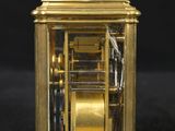 a gold clock that is sitting on a black surface