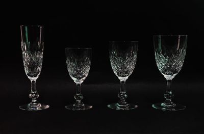 four wine glasses are lined up in a row on a black background