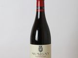 a bottle of red wine sitting on top of a wooden table