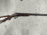 un pistolet posé par terre à côté d'un chapeau