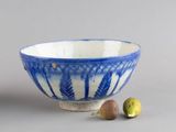 un bol bleu et blanc et quelques fruits sur la table