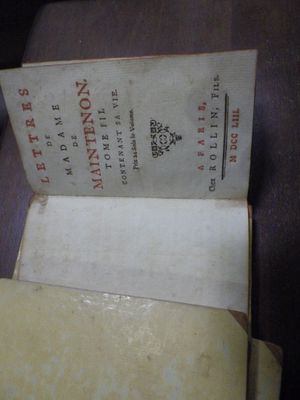 un livre ouvert posé sur une table, à côté d'une bouteille de vin