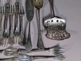 a lot of silver spoons and silverware on the table