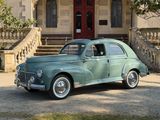 une voiture verte garée devant un immeuble